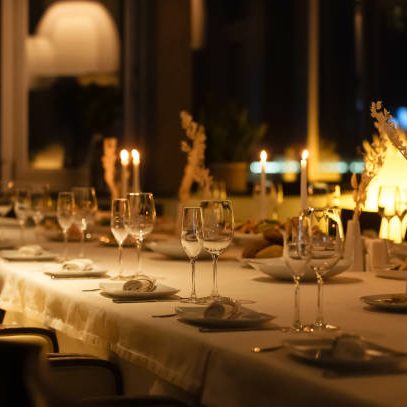A beautifully arranged dining table is set with glasses and candles, creating a warm atmosphere for guests.